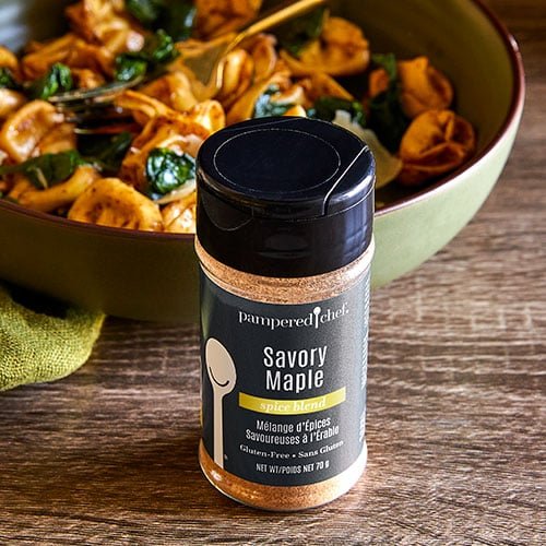 A jar of Pampered Chef Gluten-Free Savory Maple Seasoning, showcasing a blend of herbs and spices perfect for enhancing the flavor of various dishes.