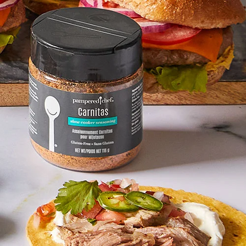 A jar of Pampered Chef Gluten-Free Carnitas Seasoning, showcasing a blend of herbs and spices perfect for enhancing the flavor of various dishes.