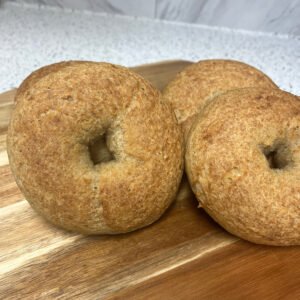 A stack of freshly baked gluten-free bagels with a golden crust and a soft interior.